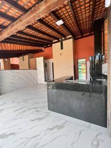 Habitación grande con suelo de mármol y techo de madera. en Casa Temporada Villagio Del Mare, en Salinópolis