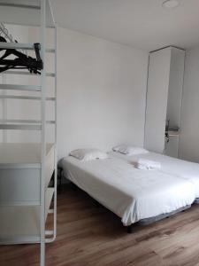 um quarto branco com uma cama e uma escada em Vila dos Avós na Figueira da Foz