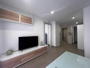 a living room with a flat screen tv on a white wall at Villa Aguas Claras in Escalona