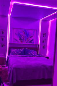 a bedroom with a bed with purple lighting at Appartement au centre d´agadir in Agadir