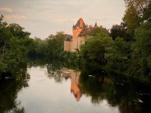 een kasteel aan de kant van een rivier bij Château de La Tour en Brenne in Rivarennes