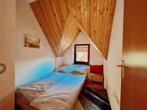 a small bedroom with a bed and a wooden ceiling at Villa "Pahulja" - Vlašić in Vlasic