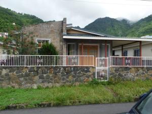 ein Haus mit einer Steinmauer und einem Zaun in der Unterkunft Tropical Home Oasis in Soufrière