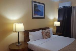 ein Schlafzimmer mit einem Bett und zwei Lampen an Tischen in der Unterkunft Tropical Home Oasis in Soufrière