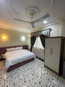 1 dormitorio con 1 cama y ventilador de techo en GEORGE VEE HOTEL LTD en Kumasi