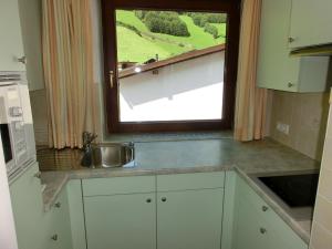 a kitchen with a sink and a window at Gästehaus Hollerer in Gerlos