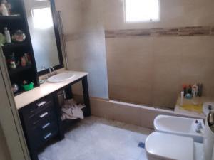 een badkamer met een wastafel en een douche bij 4 hijos in La Banda