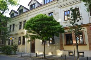 un edificio con un árbol delante de él en Charming 2-Level Apartment - Podgórze, Old Town, en Cracovia