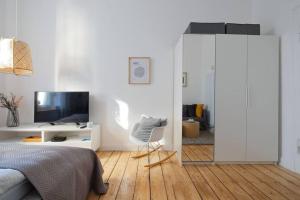 1 dormitorio con 1 cama, TV y espejo en Design Altbautraum Wuppertal en Wuppertal