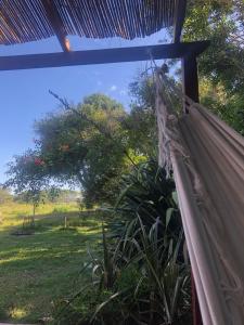 a hammock in a room with a view of a field at La casita de Valizas in Barra de Valizas