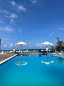 特赖里Villa Ava Kite - Guajiru的一座带遮阳伞的游泳池,其背景是大海