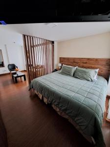 1 dormitorio con 1 cama grande y cabecero de madera en Acogedor Apartasuite cerca al Parque de la 93, en Bogotá