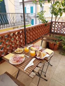 a breakfast table with food and orange juice on a balcony at Pura vida in Viareggio