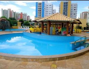 a large blue swimming pool with a gazebo at Condominio Residencial Thermas Place in Caldas Novas