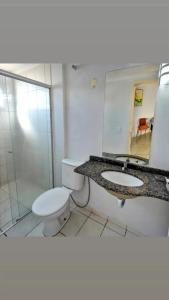 a bathroom with a toilet and a sink and a mirror at Condominio Residencial Thermas Place in Caldas Novas