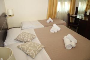 Dos camas en una habitación de hotel con toallas. en Villa Adriana Hotel, en Tívoli