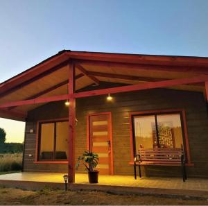 uma pequena cabana com um banco à frente em Cabaña Refugio Eluney em Villarrica