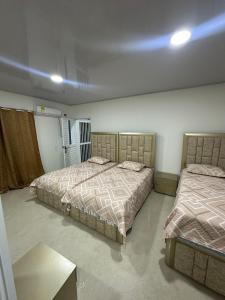 1 Schlafzimmer mit 2 Betten und einem Tisch in der Unterkunft Three Cay Suites in Providencia