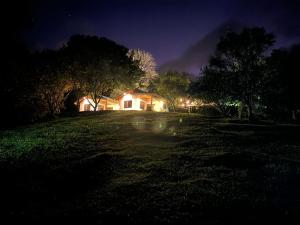 a house on a field at night at Casa areno lodge in Bijagua