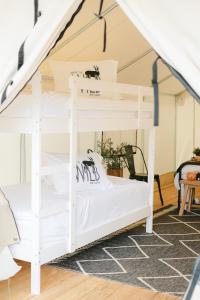 a bunk bed with white bunk beds in a room at Deluxe Glamping Tents at Lake Guntersville State Park in Guntersville