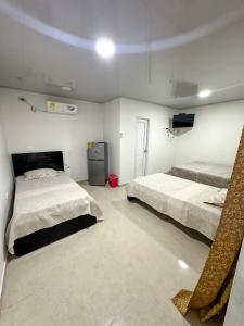 ein Schlafzimmer mit 2 Betten und einem TV in der Unterkunft Three Cay Suites in Providencia