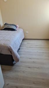 1 dormitorio con 1 cama y suelo de madera en Departamento Pucón 6 personas, en Pucón