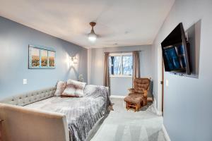 Schlafzimmer mit einem Bett, einem TV und einem Stuhl in der Unterkunft Lakefront Minnesota Vacation Rental with Dock in Annandale