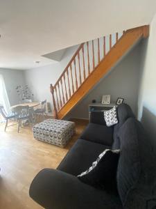 a living room with a couch and a staircase at Family Home In The Forest Of Dean in Coleford