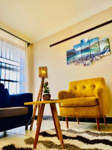 ein Wohnzimmer mit einem gelben Sofa und einem Tisch in der Unterkunft The cape vills in Kampala