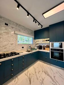 a kitchen with blue cabinets and marble counter tops at Chácara Recanto Viva a Vida in Mairinque