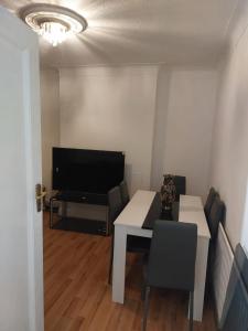 a living room with a table and a television at Catford Homely Home in Hither Green