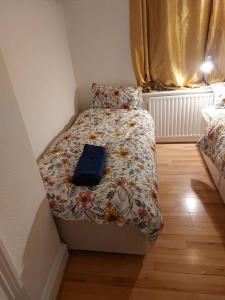 a small bedroom with a bed with a floral bedspread at Catford Homely Home in Hither Green