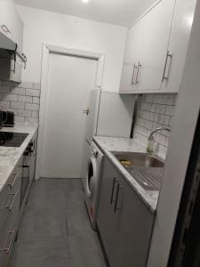 a kitchen with a sink and a washing machine at Catford Homely Home in Hither Green