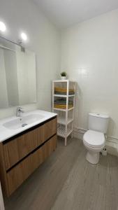 bagno con servizi igienici, lavandino e specchio di Charming Beachfront apartment a Murcia