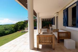 a patio with chairs and tables on a house at Villa Mawali in Sainte-Anne