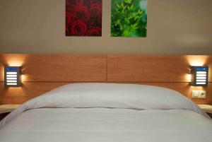 A bed or beds in a room at Manzil Hotel