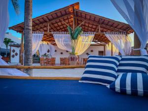 a bed with blue and white pillows in front of a patio at Isla Beach Hotel in Pecém
