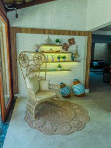 a wicker chair sitting in a room with vases at Isla Beach Hotel in Pecém