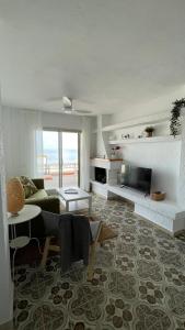 sala de estar con sofá y TV en Charming Beachfront apartment, en Murcia
