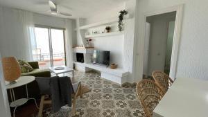 sala de estar con sofá y TV en Charming Beachfront apartment, en Murcia