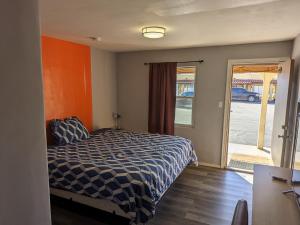 a bedroom with a bed and a sliding glass door at El Rey Motel in Globe