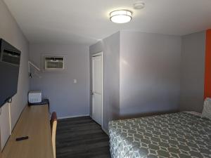 1 dormitorio con cama, mesa y puerta en El Rey Motel, en Globe