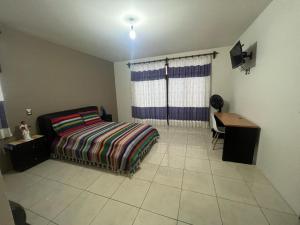 una camera con letto e scrivania di Alojamientos OHANA a Città di Oaxaca
