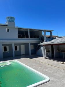 a large building with a swimming pool in front of it at Beach House Barra - Casa de temporada in Conceição da Barra