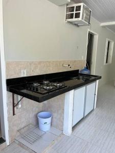a kitchen with a stove and a counter top at Beach House Barra - Casa de temporada in Conceição da Barra