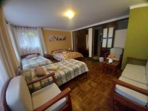 a hotel room with two beds and a couch at Hotel Qhawarina de Casas Kolping Bolivia S.R.L. in Sucre