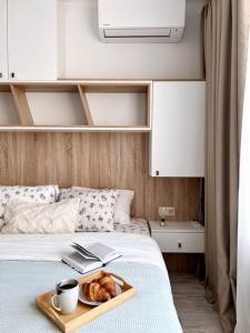 a tray of bread and a book on a bed at Seaside apartment Tyndzha in Pomorie