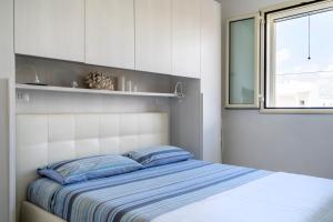 um quarto com uma cama com almofadas azuis e uma janela em Casa Luna 100 mt dalla spiaggia em Maruggio
