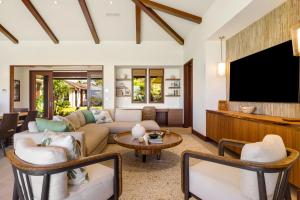 a living room with a couch and a flat screen tv at Luxury 5BR Vacation Home w Pool in Koloa