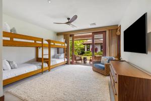 a bedroom with two bunk beds and a flat screen tv at Luxury 5BR Vacation Home w Pool in Koloa +21 photos